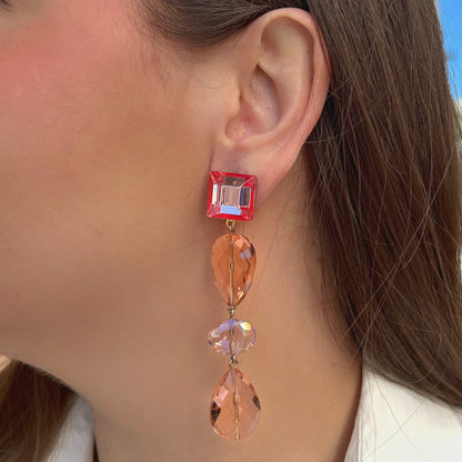 Boucles d'oreilles à clips Suzanna Rose Francine Bramli Paris, attaches carrées en résine rose translucide et pendentifs composés de perles facettées champagne et pêche rosée – Divinity Sète.