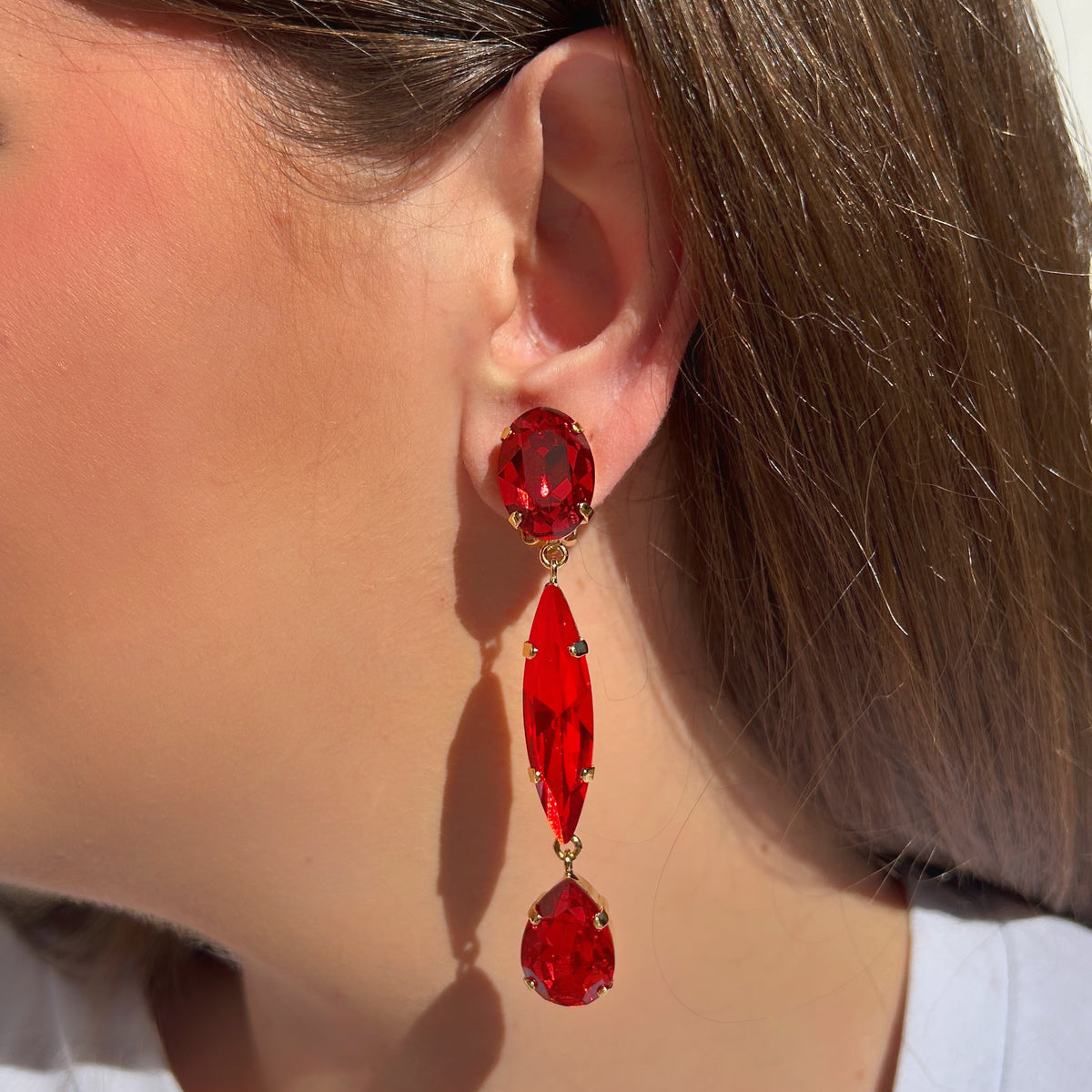 Boucles d’oreilles pendantes Talia Cerise Crézus à clips, trois cristaux rouges facettés de formes ovale, navette et goutte sur montures dorées