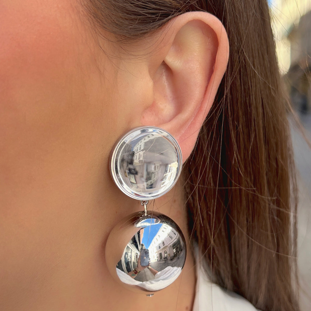 Boucles d'oreilles à clips Thea Silver Francine Bramli Paris, clip rond bombé argenté effet miroir et grande perle sphérique suspendue finition argent brillant – Divinity Sète.