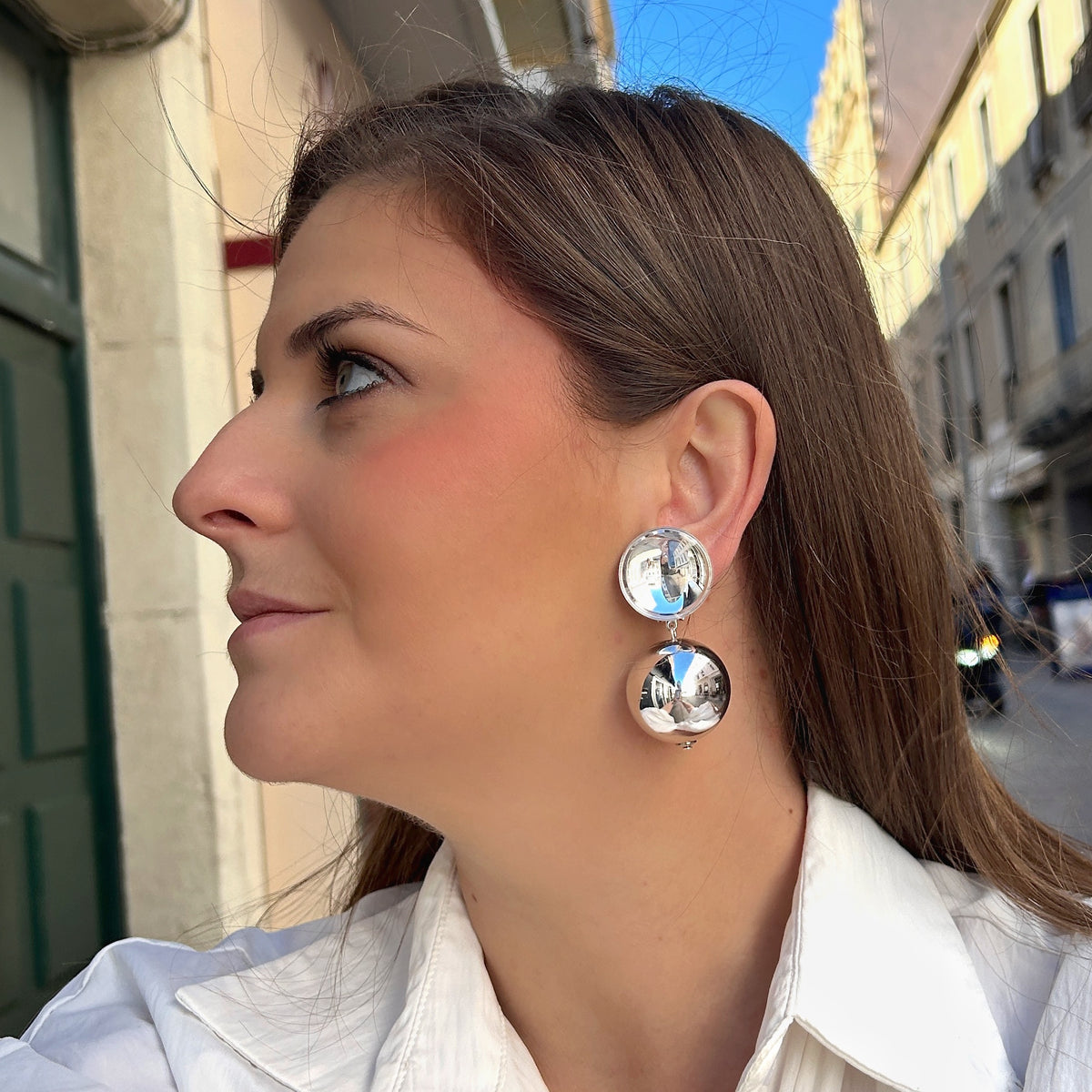 Boucles d'oreilles à clips Thea Silver Francine Bramli Paris, clip rond bombé argenté effet miroir et grande perle sphérique suspendue finition argent brillant – Divinity Sète.
