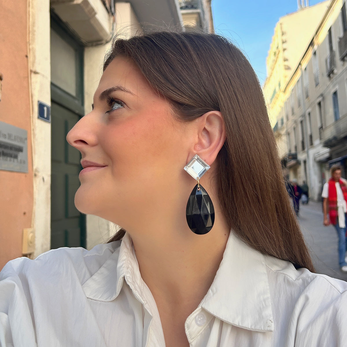Boucles d’oreilles Théona Noir à clips Francine Bramli Paris, cabochons carrés transparents et grandes gouttes noires facettées.