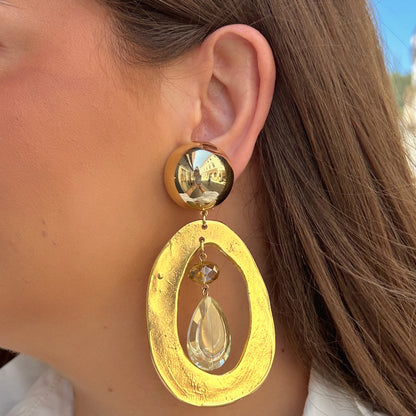 Boucles d'oreilles Tillo Gold Francine Bramli dorées avec goutte en cristal facetté portées
