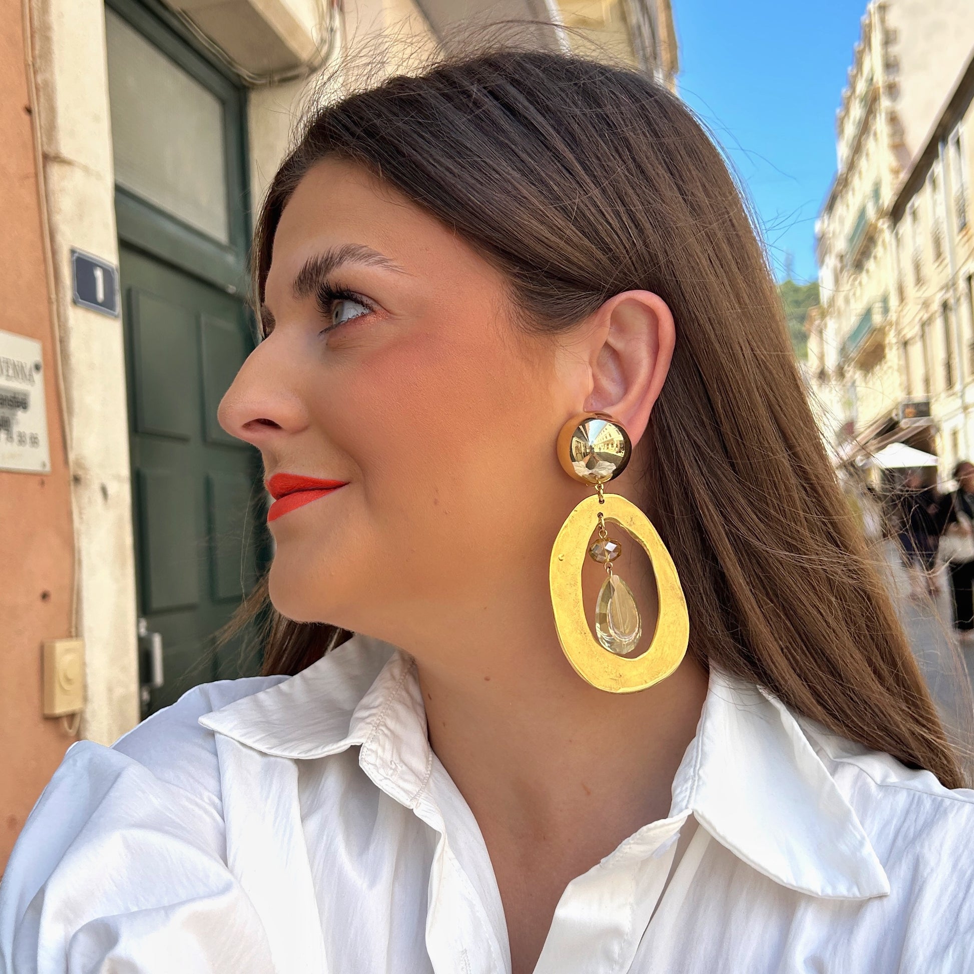 Boucles d'oreilles Tillo Gold Francine Bramli dorées avec goutte en cristal facetté portées