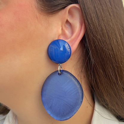 Boucles d’oreilles Tortuga Bleu à clips Francine Bramli Paris, cabochons ronds bleu électrique brillant et grands pendentifs circulaires bleu lavande texturés, reliés par des anneaux argentés.