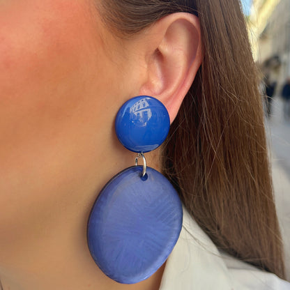 Boucles d’oreilles Tortuga Bleu à clips Francine Bramli Paris, cabochons ronds bleu électrique brillant et grands pendentifs circulaires bleu lavande texturés, reliés par des anneaux argentés.