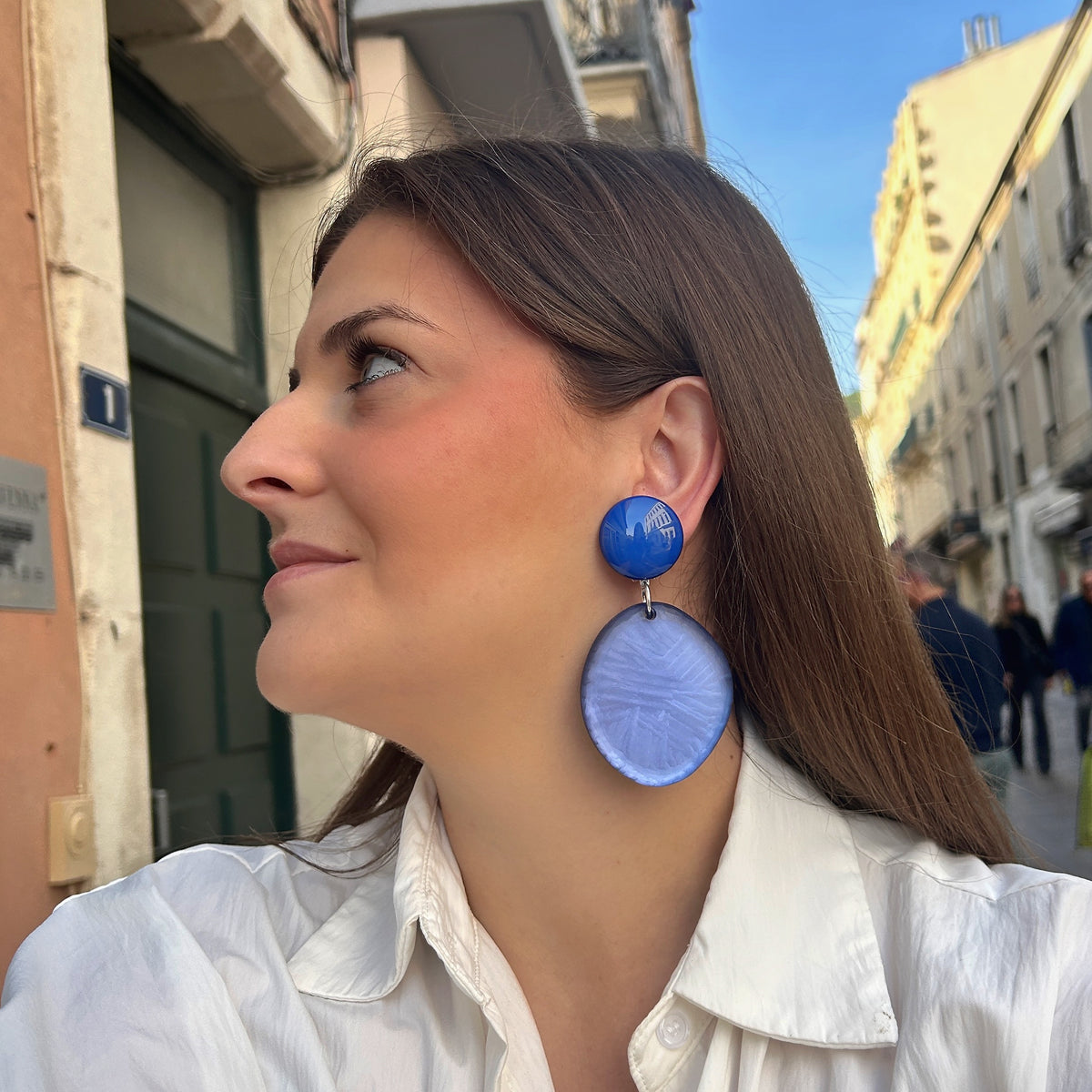 Boucles d’oreilles Tortuga Bleu à clips Francine Bramli Paris, cabochons ronds bleu électrique brillant et grands pendentifs circulaires bleu lavande texturés, reliés par des anneaux argentés.