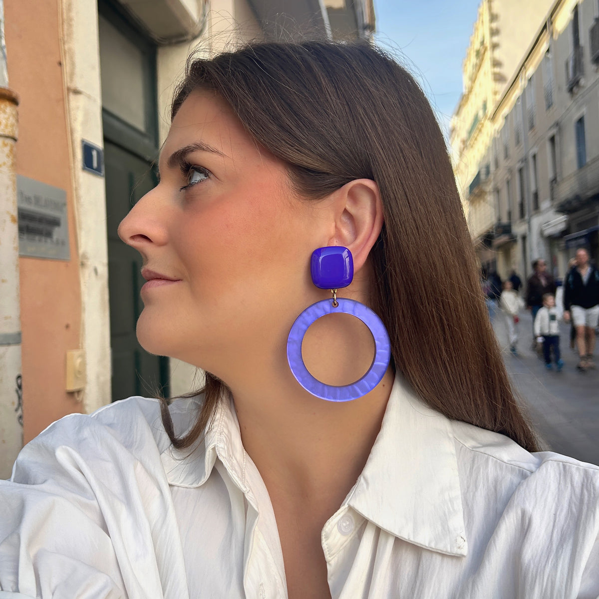 Boucles d’oreilles Veronica M Violet à clips Francine Bramli Paris, cabochons carrés violets et grands anneaux circulaires ajourés.