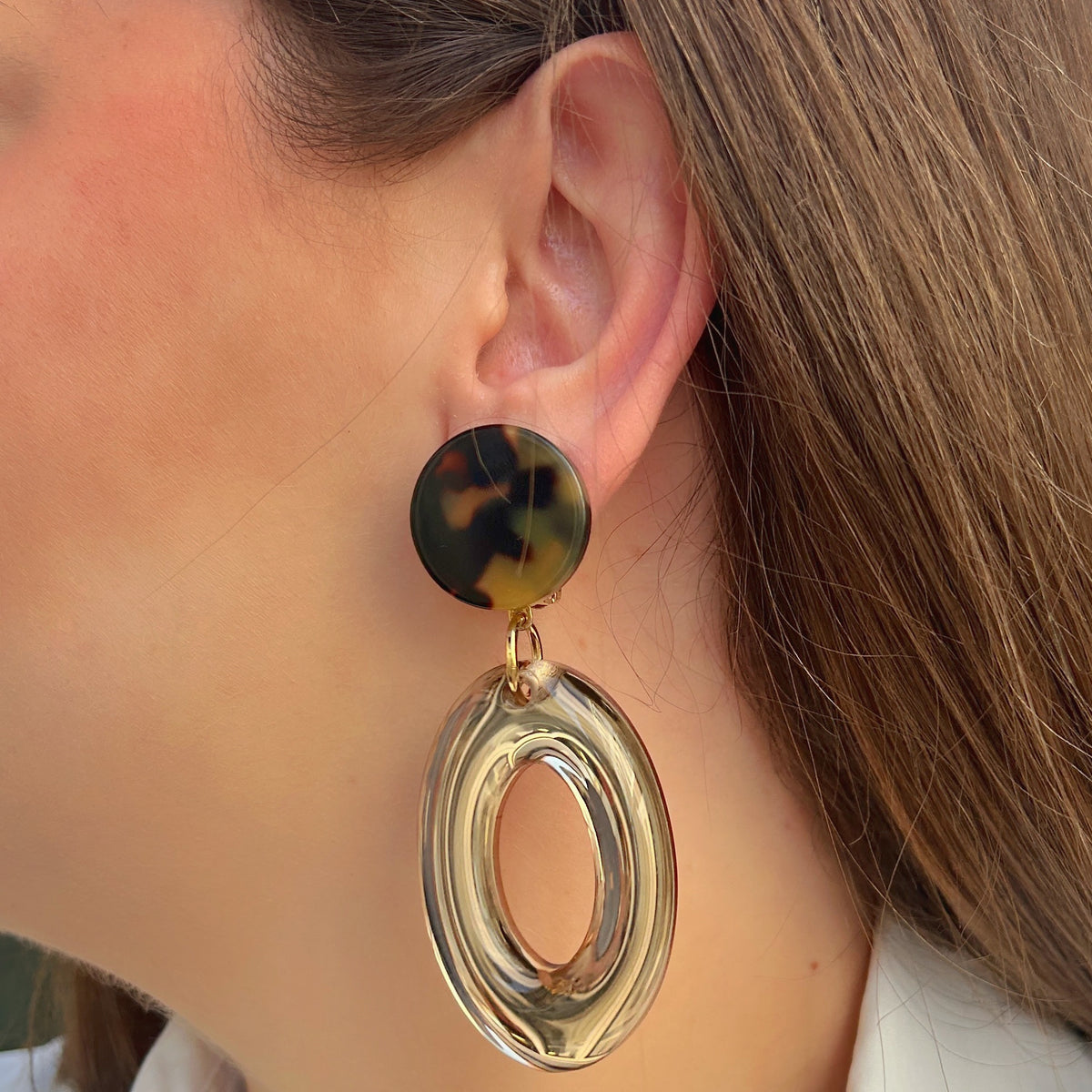 Boucles d’oreilles Vivas Champagne à clips Francine Bramli Paris, cabochons ronds effet écaille marron et ambre et grands anneaux ovales transparents champagne.