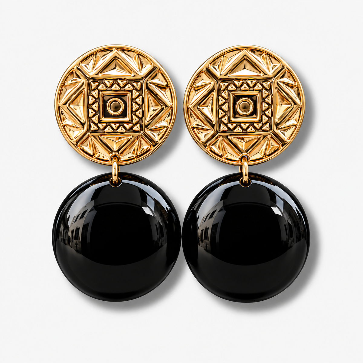 Boucles d’oreilles Zoé Gold Noir à clips Francine Bramli Paris, cabochons ronds dorés aux motifs géométriques en relief et grandes sphères noires brillantes, disponibles chez Divinity Sète.