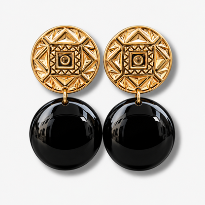 Boucles d’oreilles Zoé Gold Noir à clips Francine Bramli Paris, cabochons ronds dorés aux motifs géométriques en relief et grandes sphères noires brillantes, disponibles chez Divinity Sète.