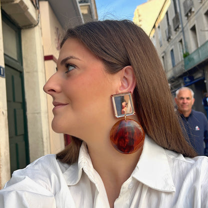 Boucles d’oreilles Zoé Marron Miroir à clips Francine Bramli Paris, cabochons carrés miroir argenté avec bordures translucides ambrées et grands pendentifs ronds marbrés marron, cognac et ambre, Divinity Sète.