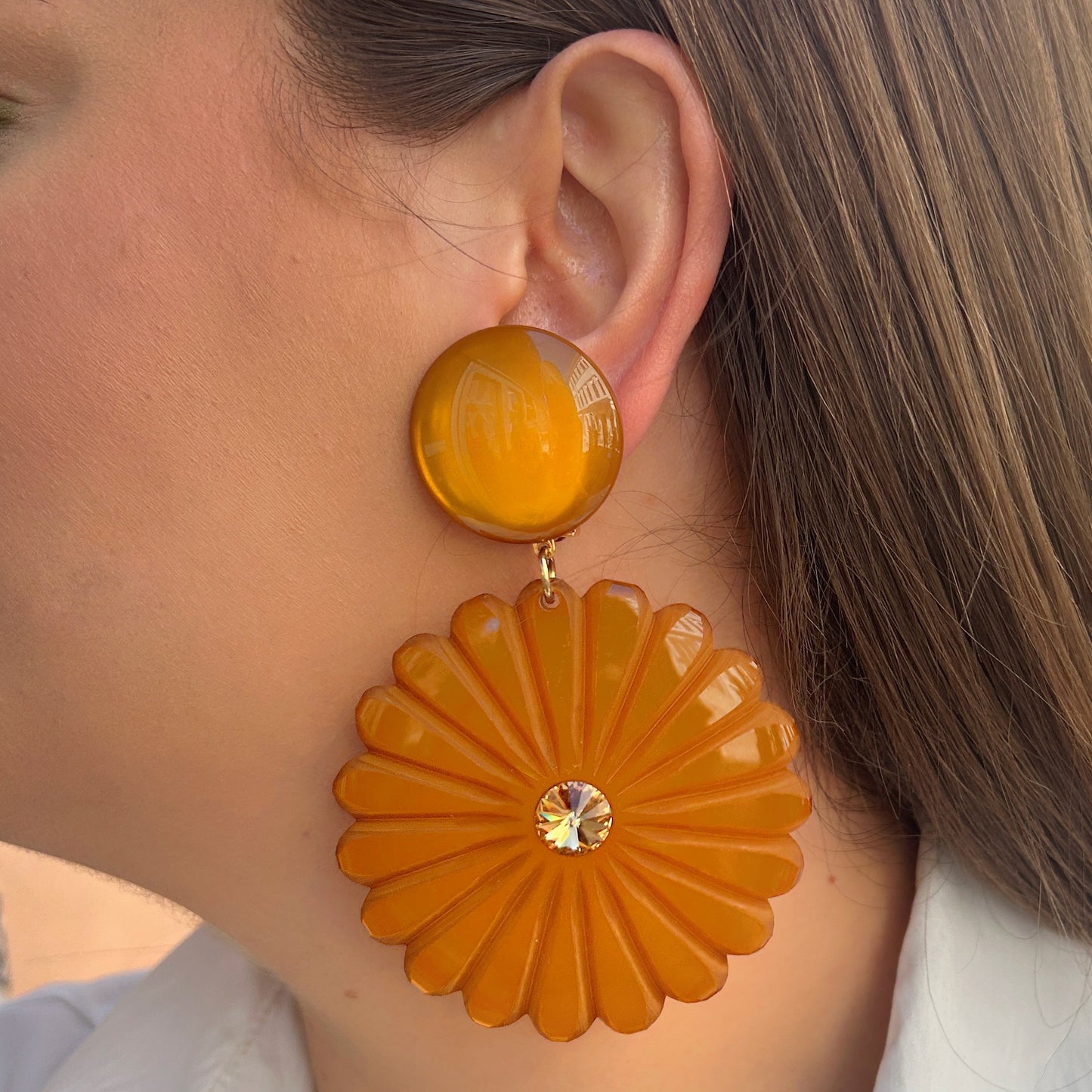 Boucles Pensée Ocre Francine Bramli Paris en résine ocre sculptée en forme de fleur avec cristal central doré.