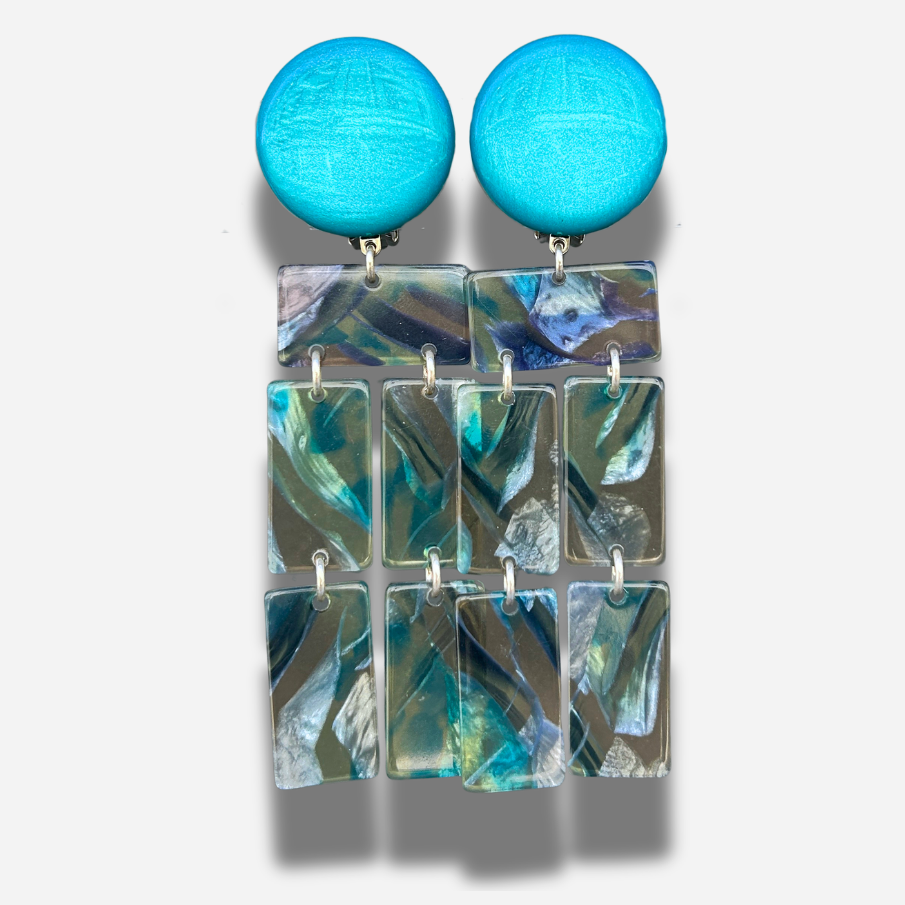 Boucles Romane Francine Bramli Paris en résine marbrée bleu turquoise et nacrée avec design graphique articulé.