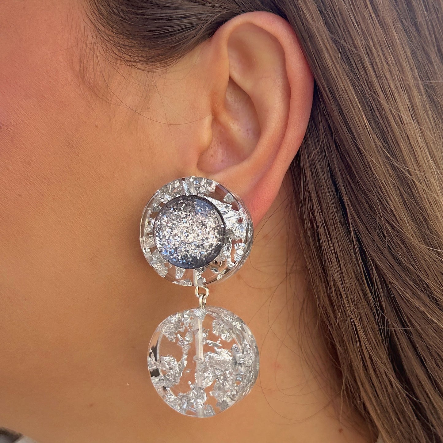 Boucles Silver Double Paillettes Francine Bramli Paris en résine transparente avec éclats argentés et cœur pailleté argenté scintillant.