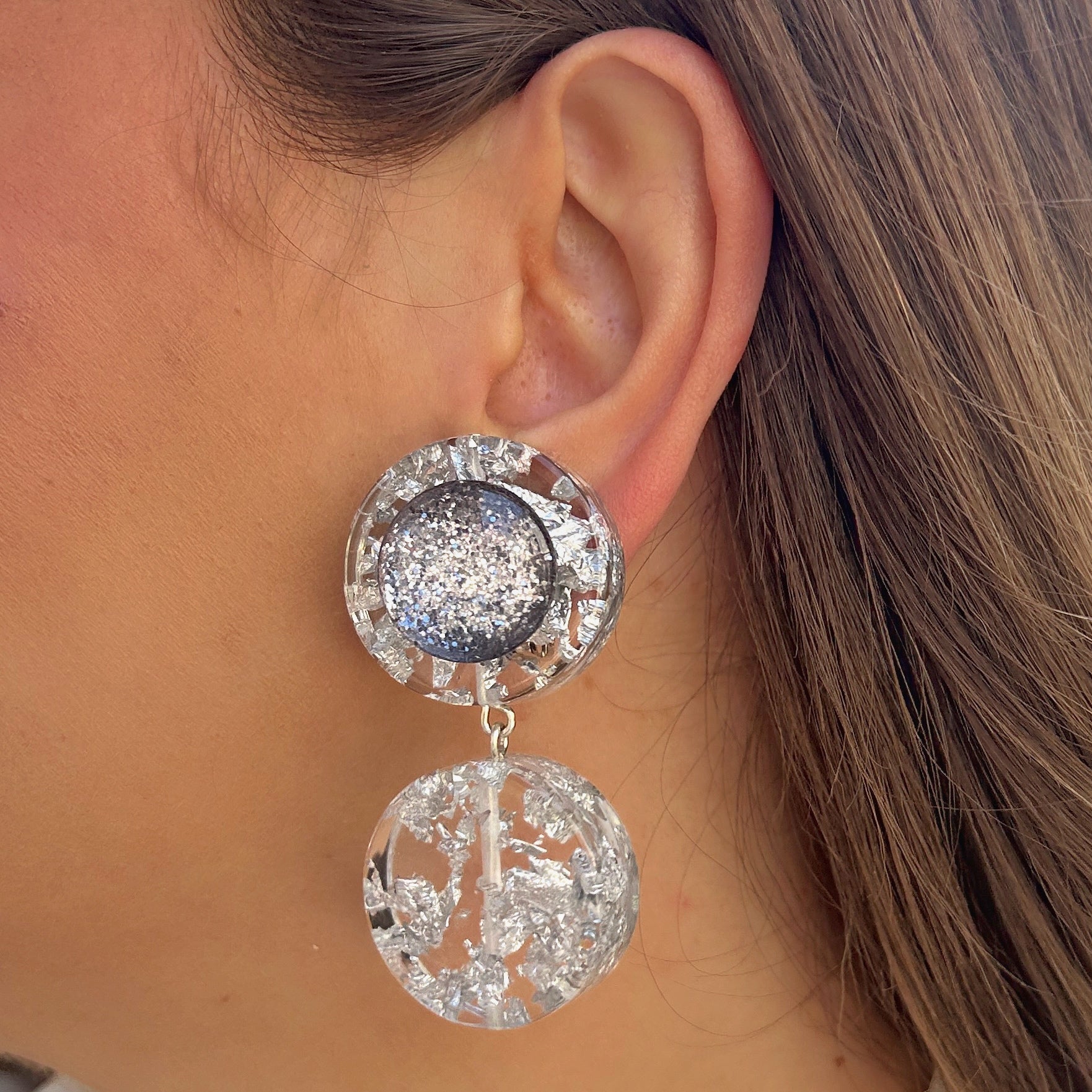 Boucles Silver Double Paillettes Francine Bramli Paris en résine transparente avec éclats argentés et cœur pailleté argenté scintillant.