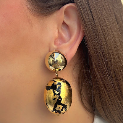 Boucles d’oreilles Sumac Noir Gold à clips Francine Bramli Paris, cabochons ronds dorés effet miroir et grandes perles ovales noires à effet feuille d’or.