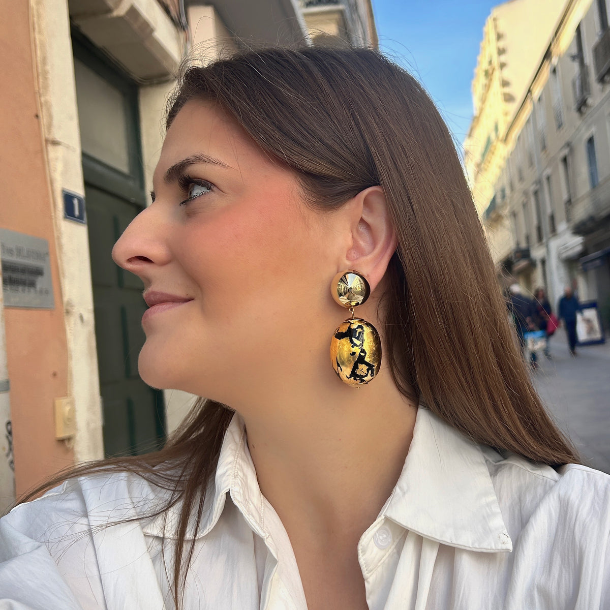 Boucles d’oreilles Sumac Noir Gold à clips Francine Bramli Paris, cabochons ronds dorés effet miroir et grandes perles ovales noires à effet feuille d’or.