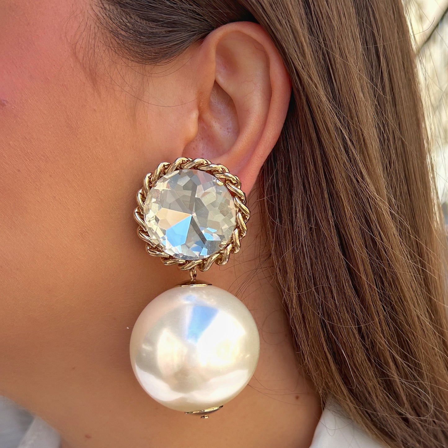 Boucles Theonie Gold XL Francine Bramli Paris avec grand cristal facetté serti dans une monture dorée torsadée et perle nacrée blanche.