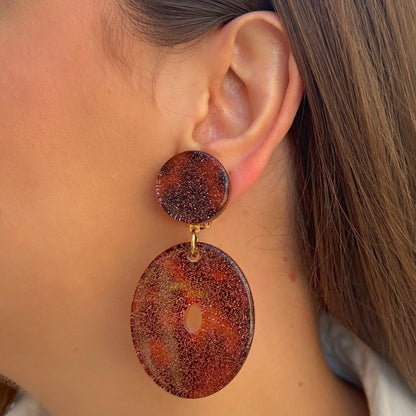 Boucles Vega Francine Bramli Paris en résine pailletée rose cuivré portées sur oreille