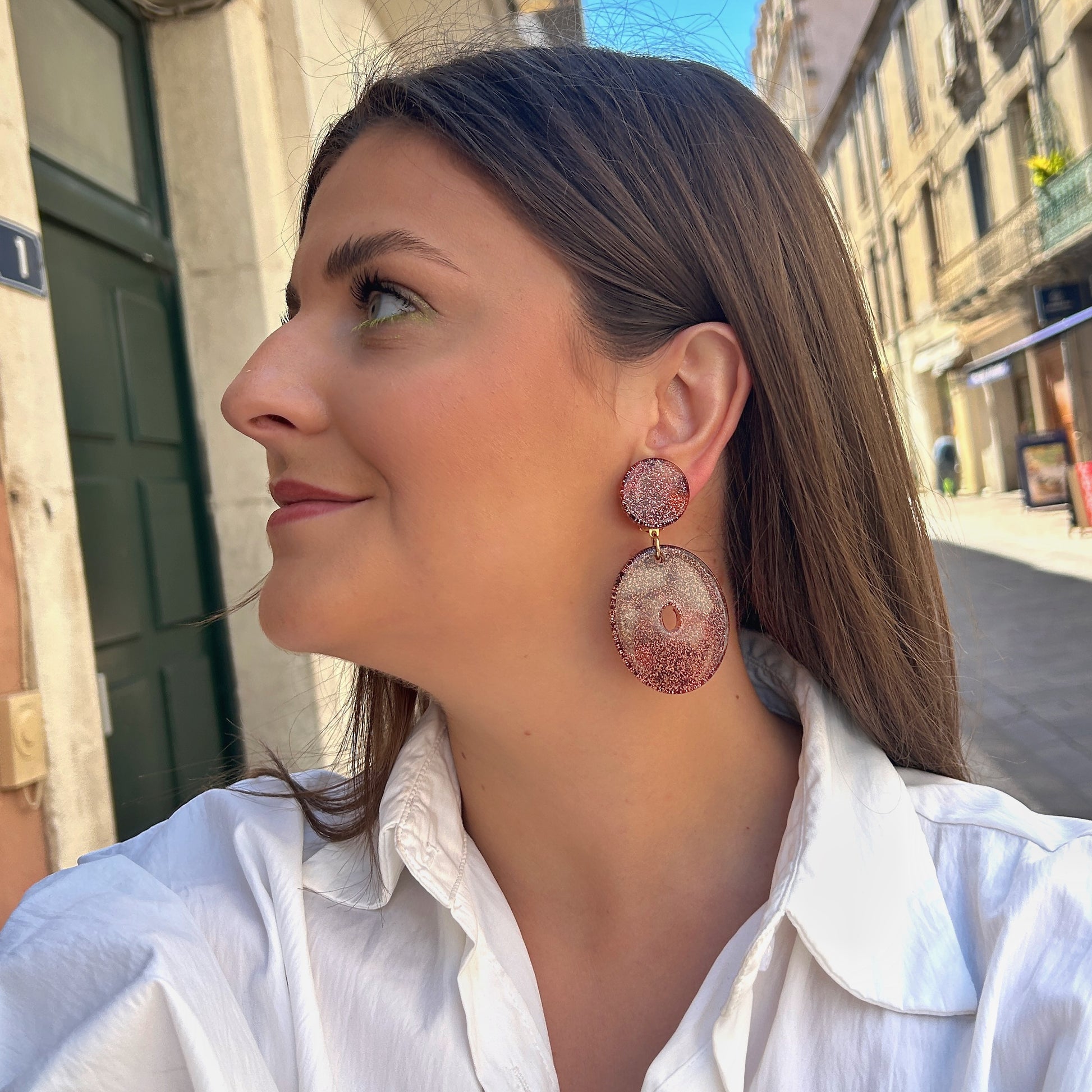 Boucles Vega Francine Bramli Paris en résine pailletée rose cuivré portées sur oreille