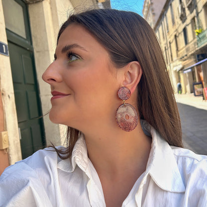 Boucles Vega Francine Bramli Paris en résine pailletée rose cuivré portées sur oreille