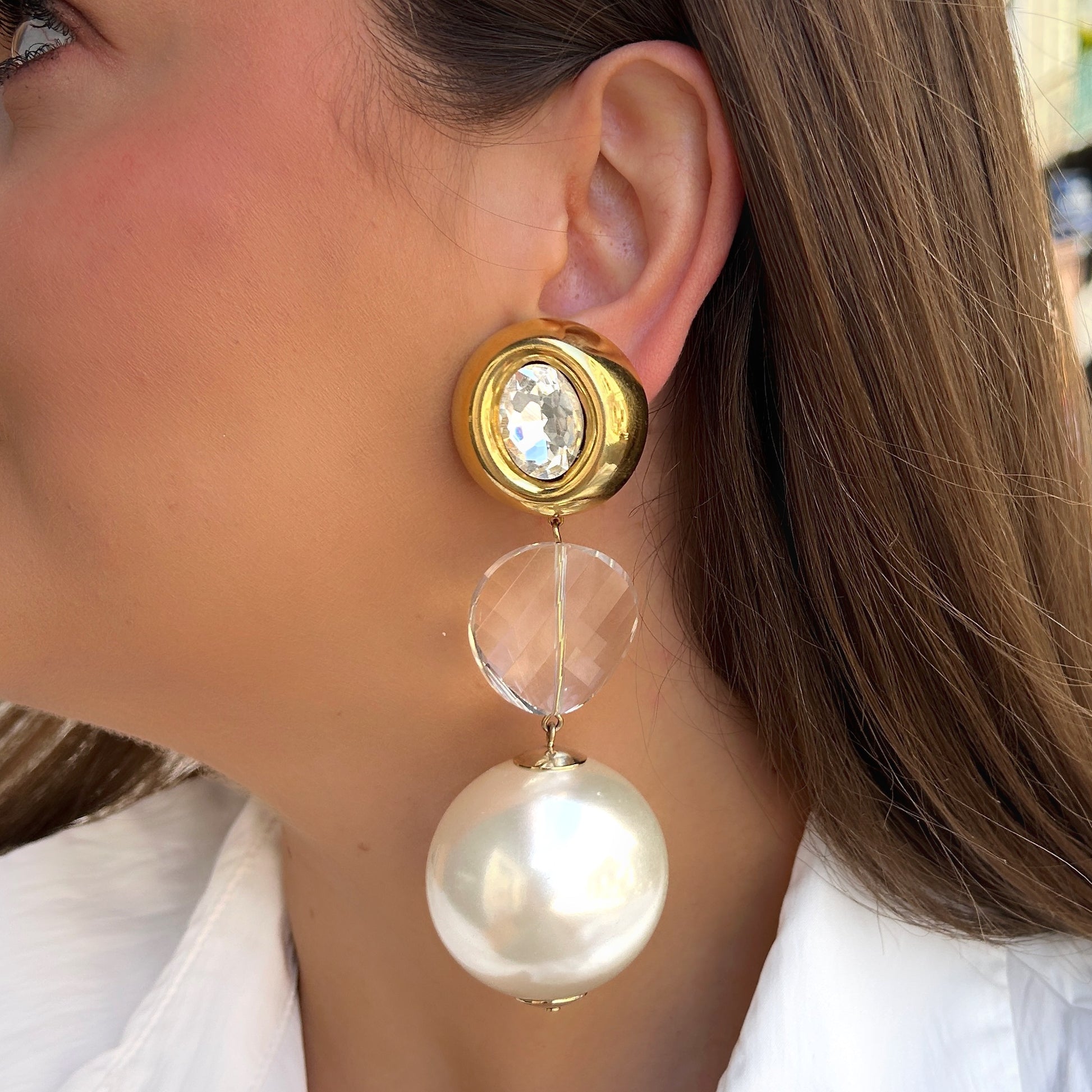 Boucles Yaelle Perles Francine Bramli Paris avec cristal transparent, monture dorée et grande perle nacrée blanche pendante.
