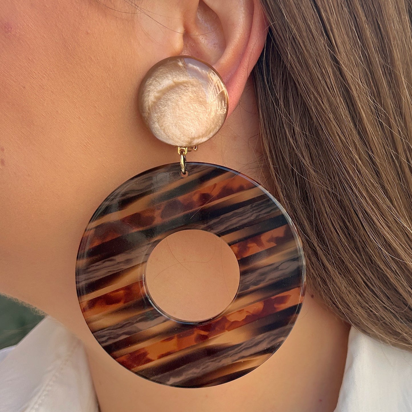 Boucles Yuki Pêche Francine Bramli Paris avec cabochon nacré pêche et grand anneau ajouré en résine effet écaille rayée.