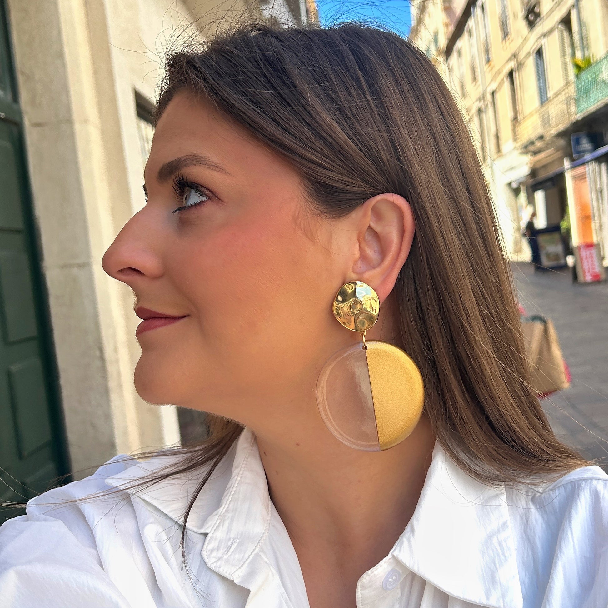 Boucles Zoé Gold Francine Bramli Paris avec pastille dorée martelée et grand disque bicolore en résine transparente et dorée.