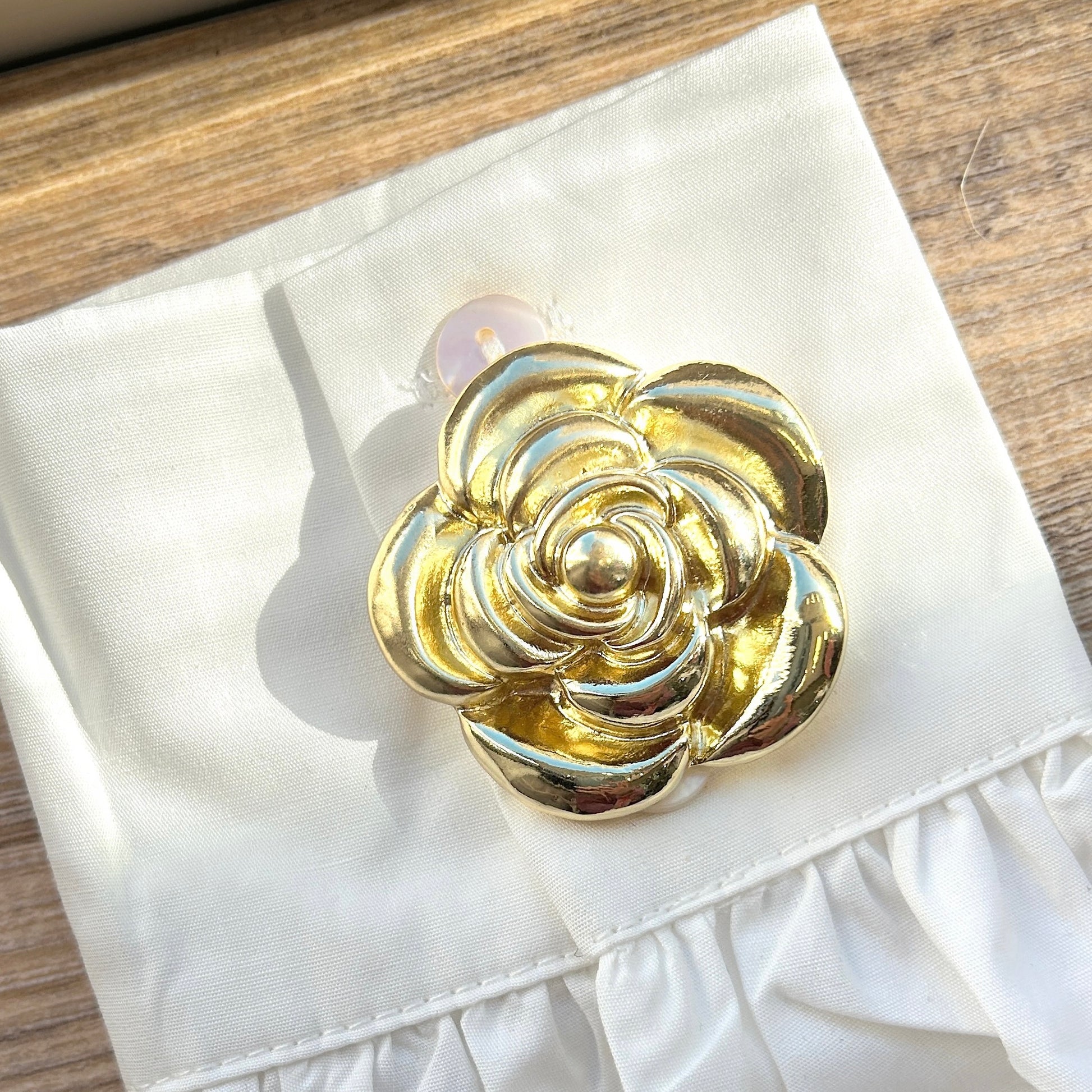 Détail broche aimantée fleur dorée finition brillante