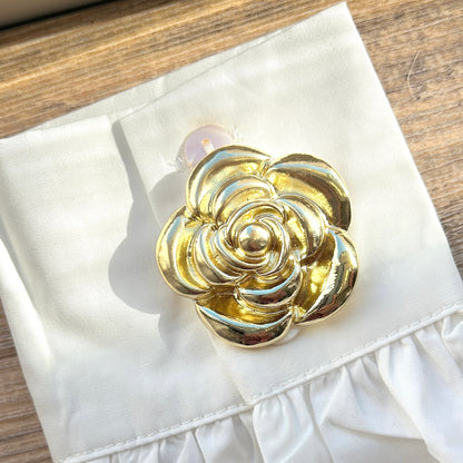 Détail broche aimantée fleur dorée finition brillante