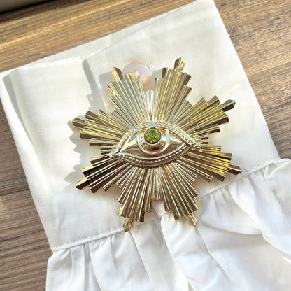 Détail broche œil doré pierre verte