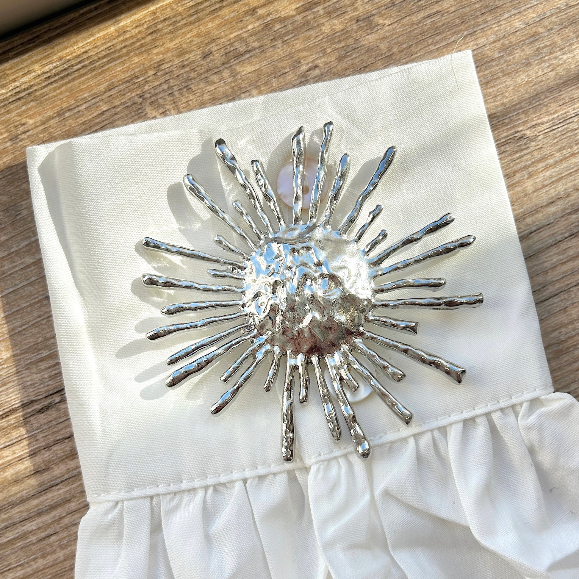 Détail broche aimantée soleil argent texturé