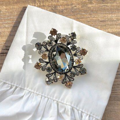 Détail broche flocon strass gris et champagne