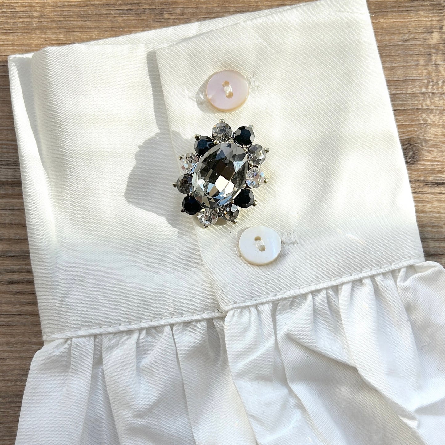 Détail broche aimantée ovale noir avec strass
