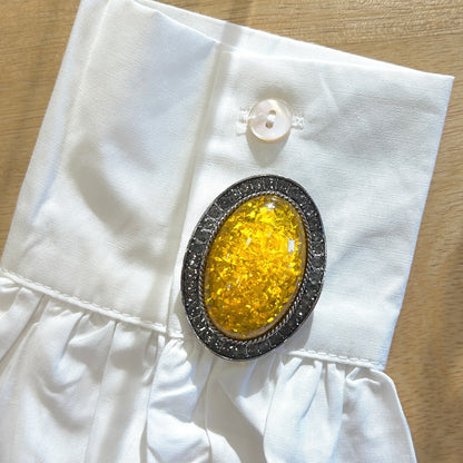 Détail broche cabochon jaune strass