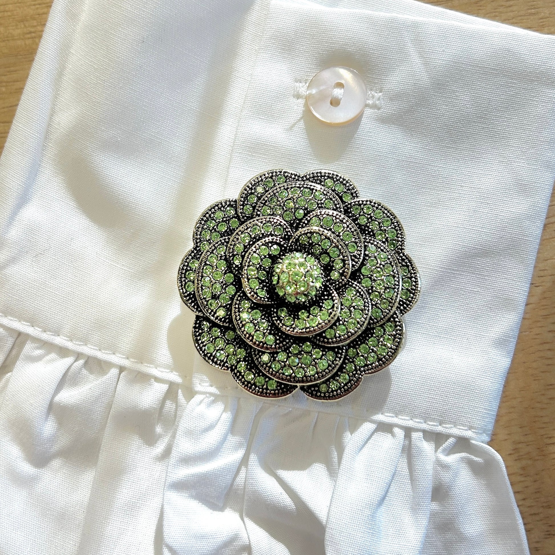Détail broche camélia verte strass