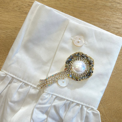 Détail broche cascade perle strass scintillants