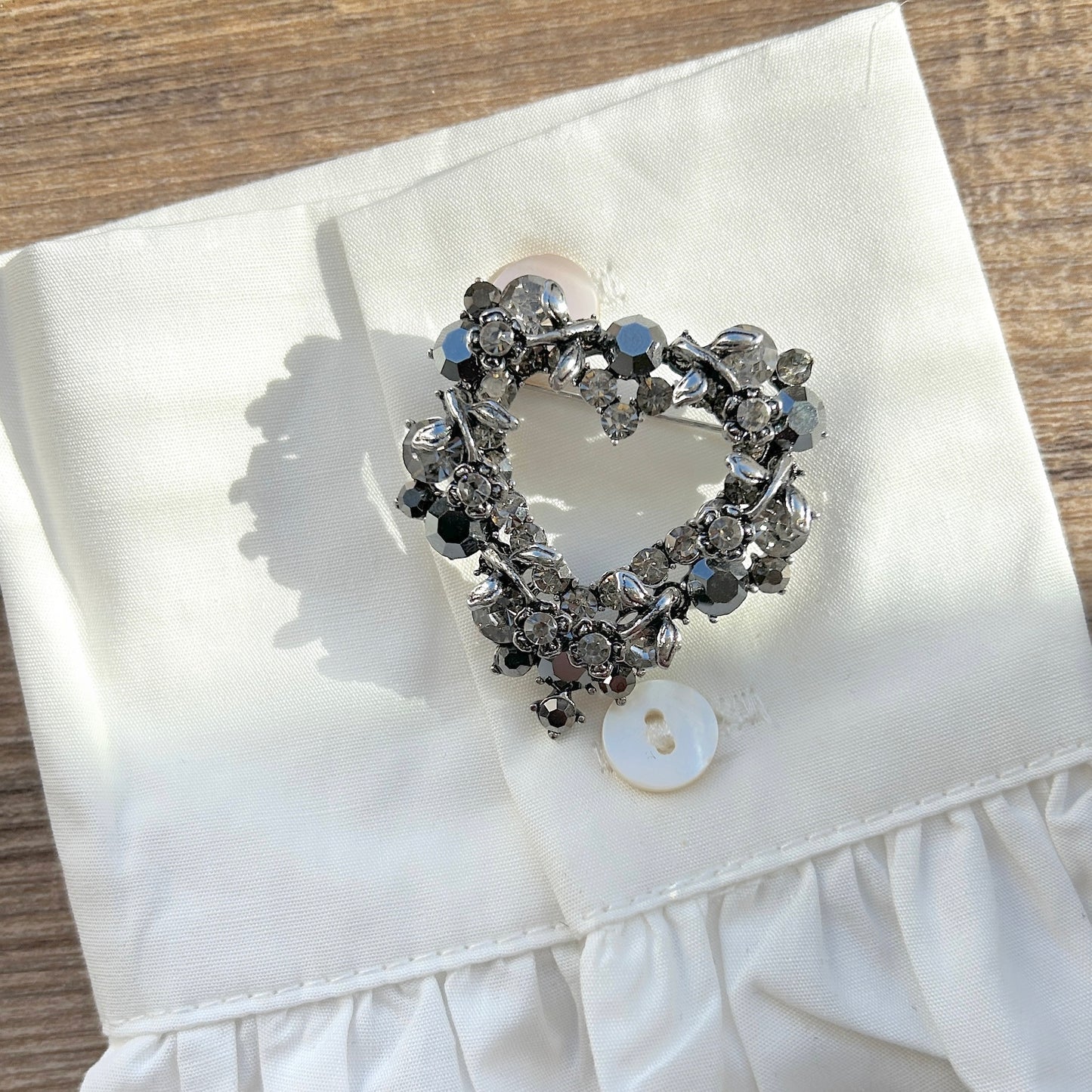 Détail broche cœur strass noirs et gris