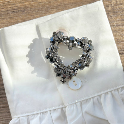 Détail broche cœur strass noirs et gris
