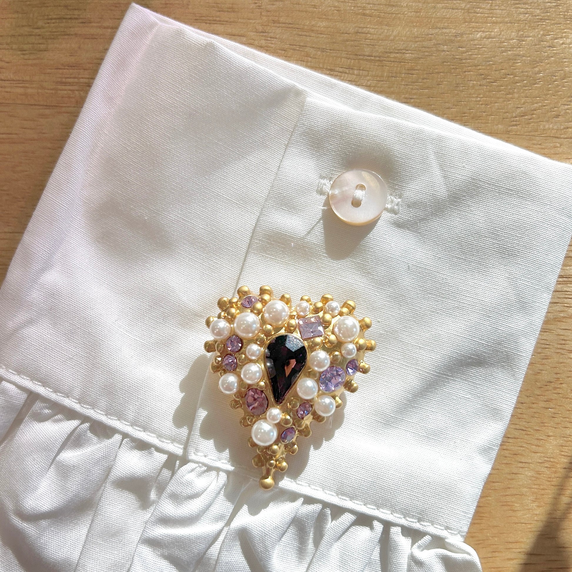 Détail broche cœur violet monture dorée et perles