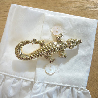 Détail broche crocodile doré relief