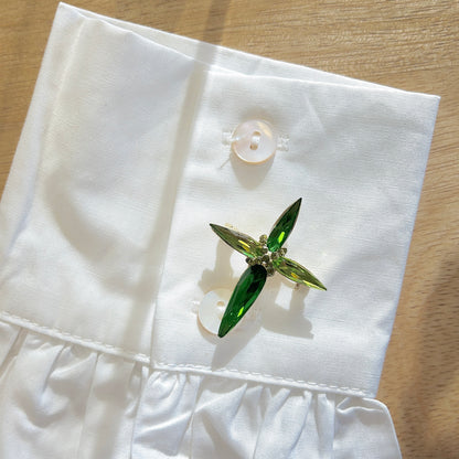 Détail broche croix verte strass