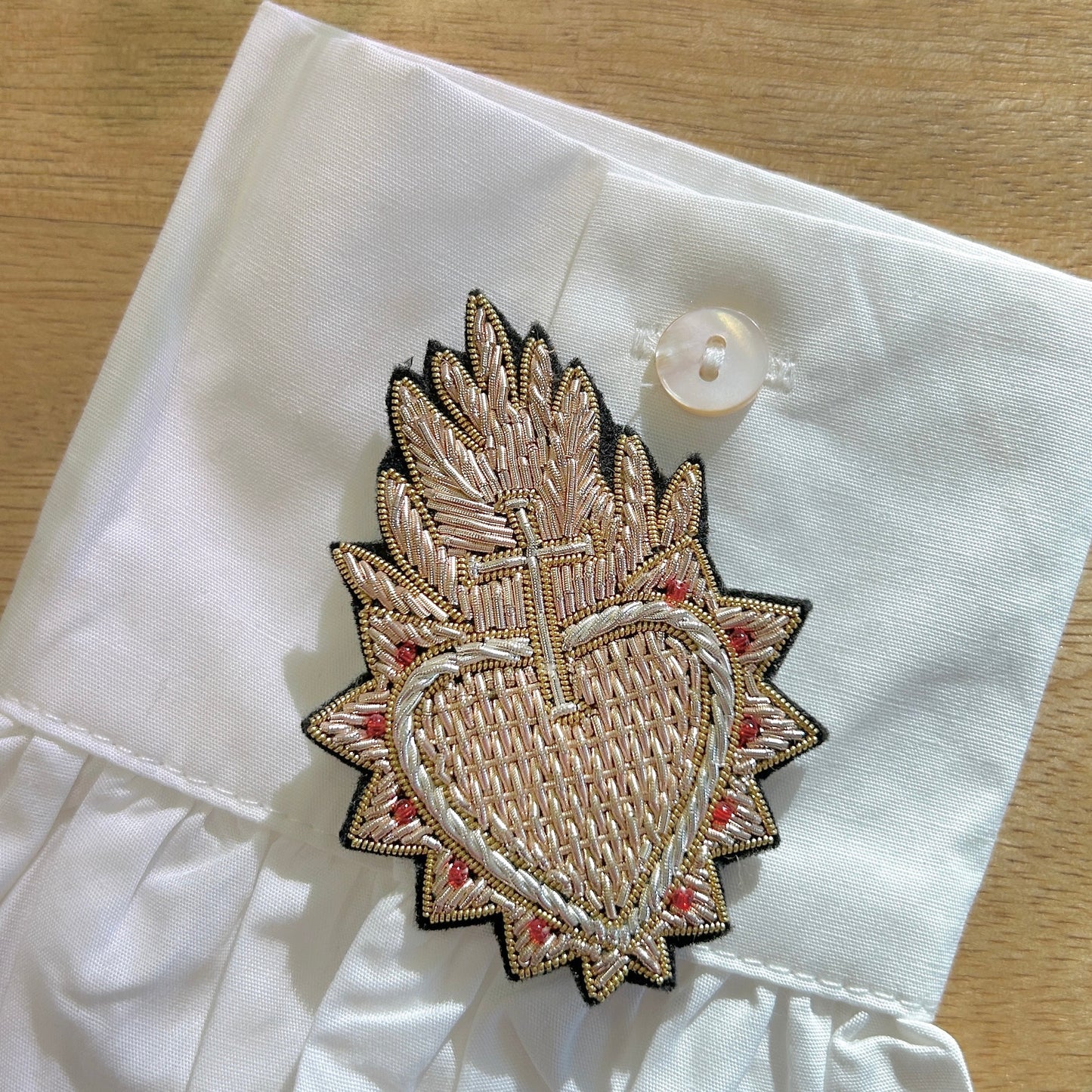 Détail broche feu sacré broderie textile