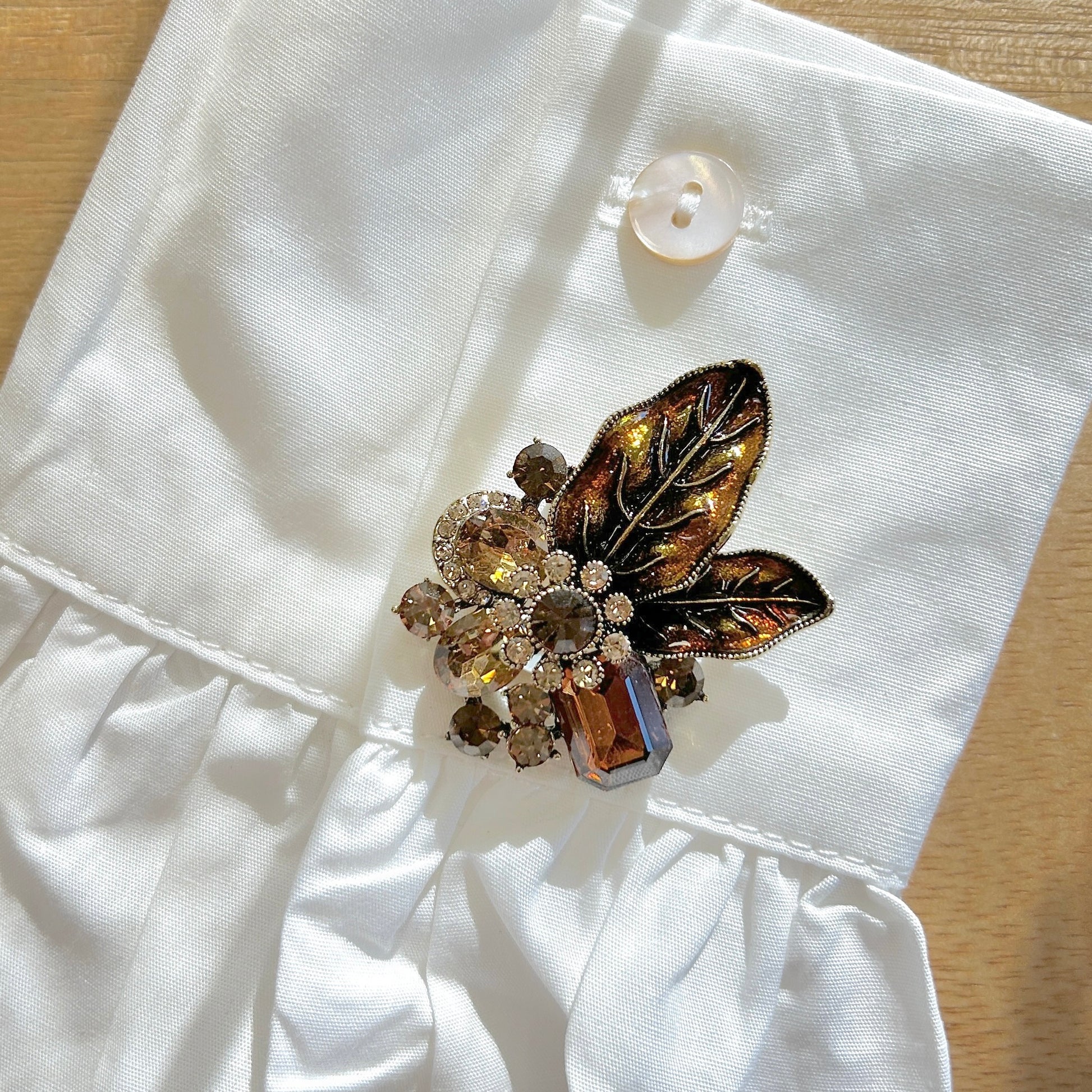 Détail broche feuillage marron strass
