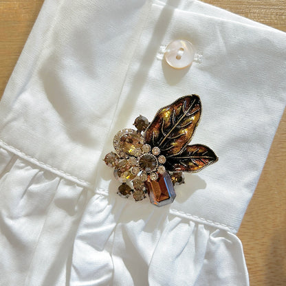 Détail broche feuillage marron strass