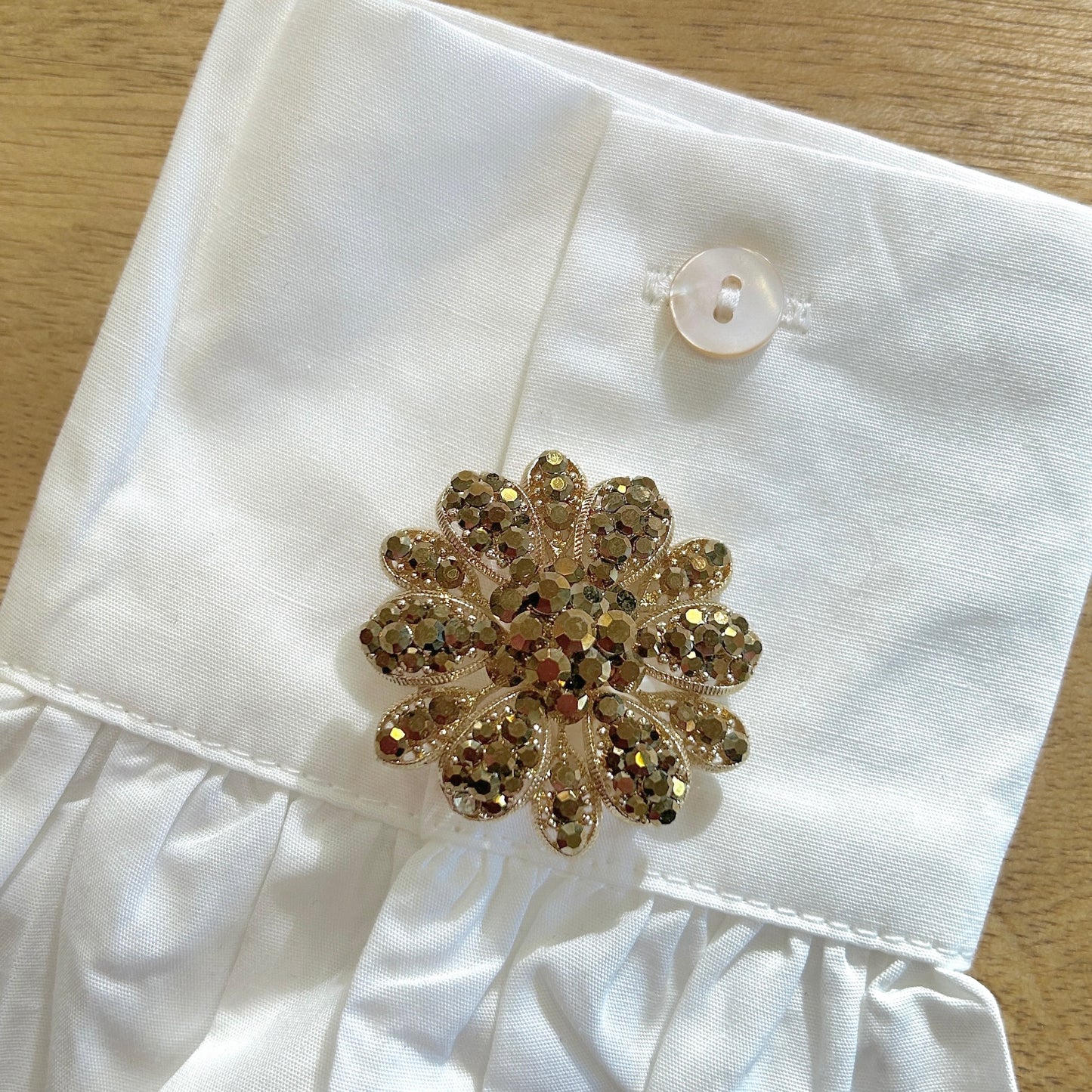 Détail broche fleur dorée strass