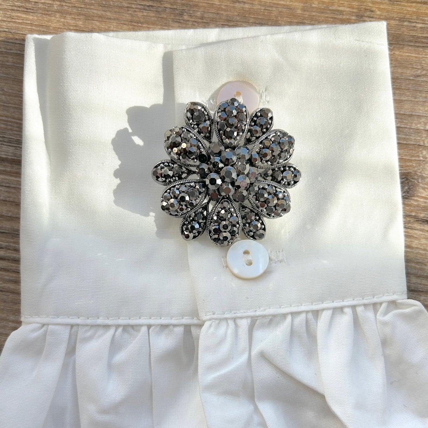 Détail broche fleur noire strass facettés
