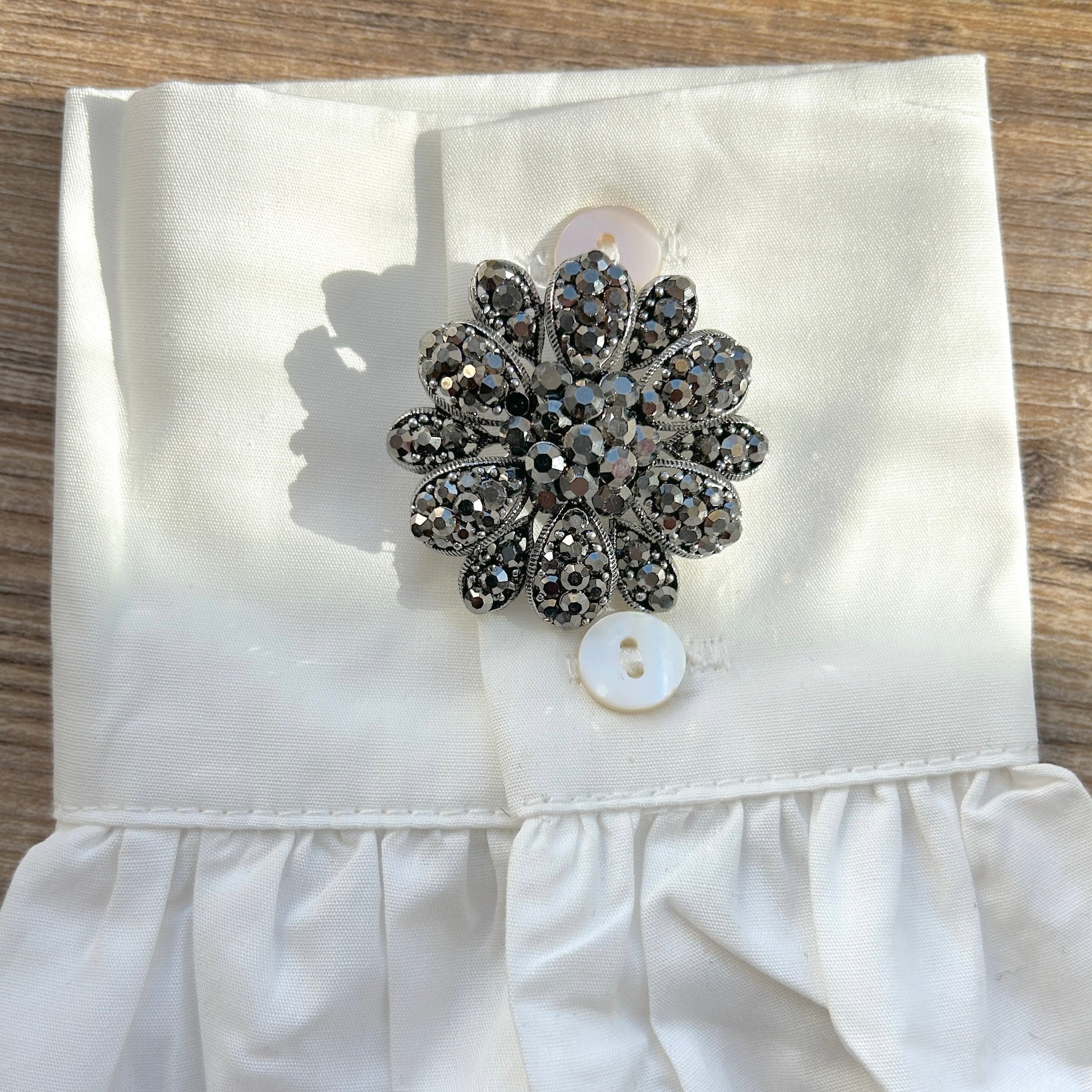 Détail broche fleur noire strass facettés