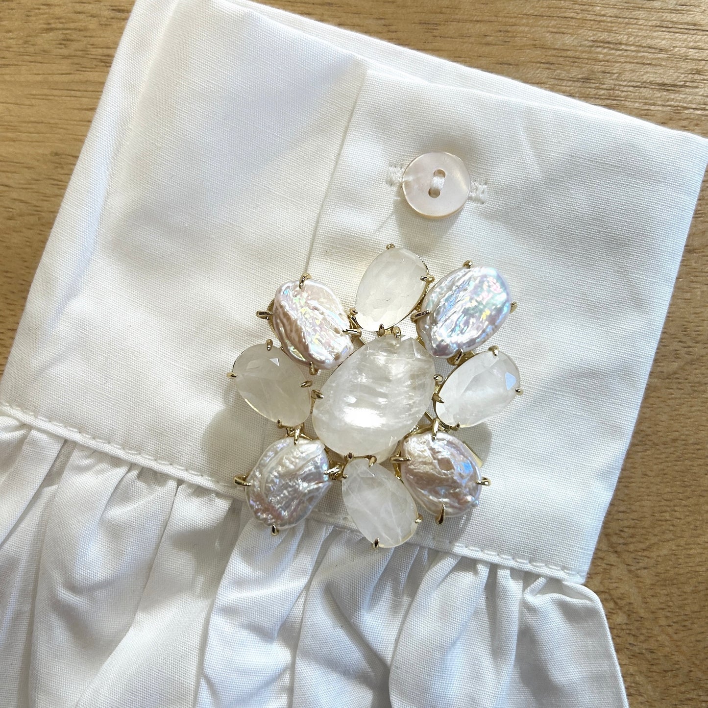 Détail broche fleur perles nacrées et pierres