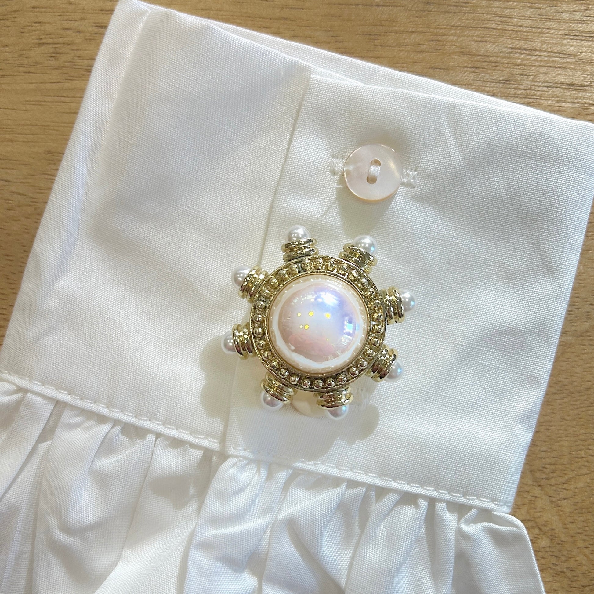 Détail broche gouvernail perle dorée